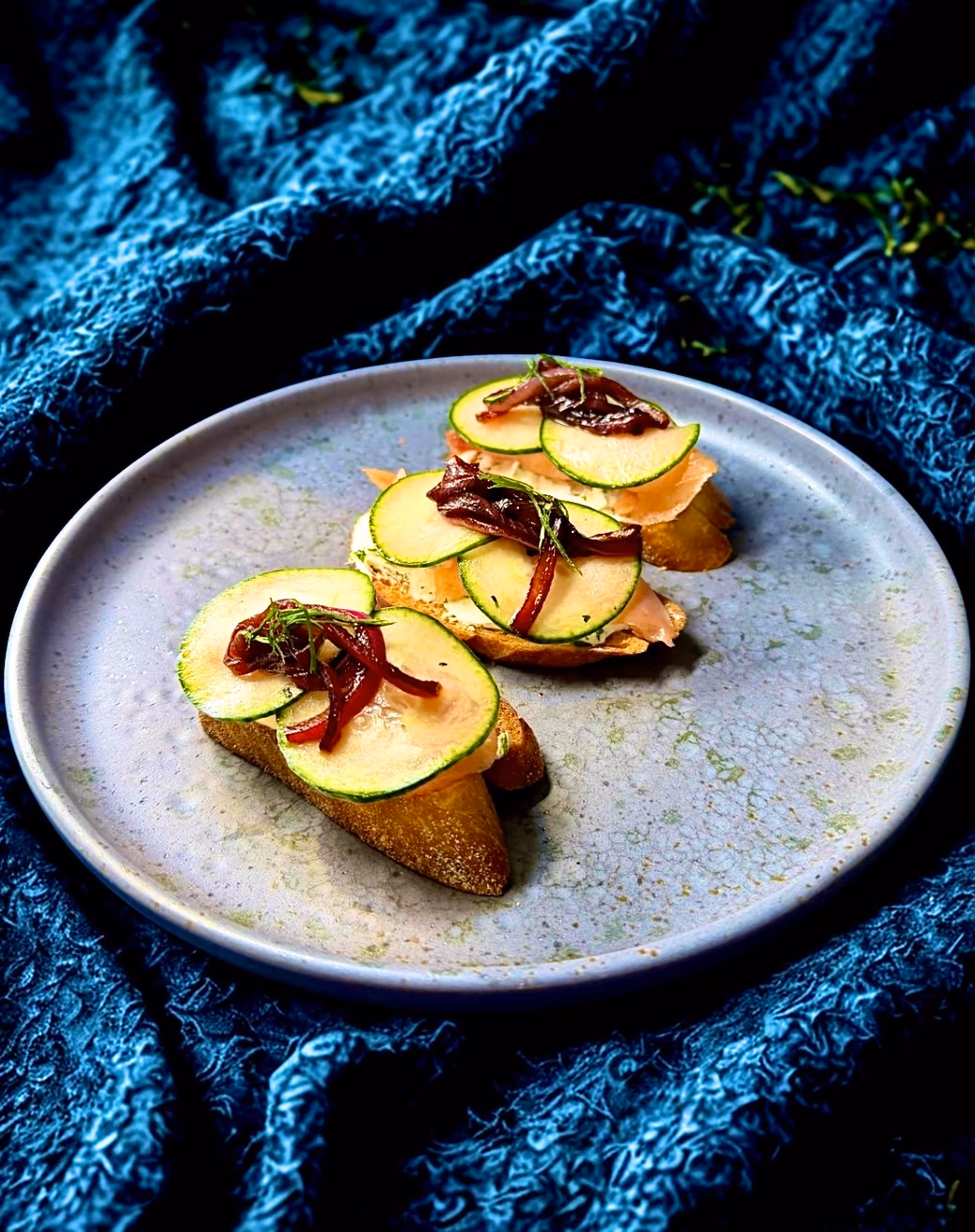 Seared crostini with caramelized onions on a grey plate