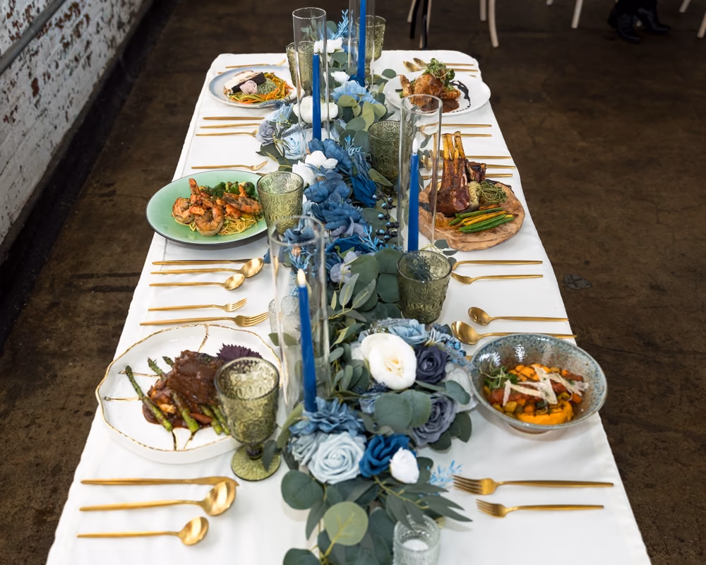 Wedding table set with blue florals and gold flatware